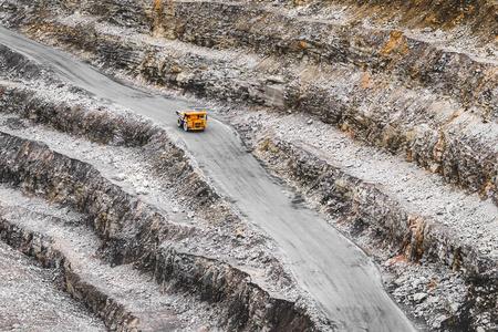现状采石场里的大型橙色采矿卡车.铁矿开采.重型采矿设备.