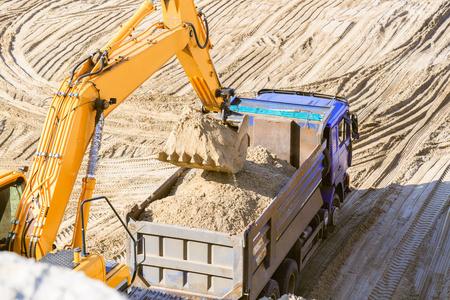 挖掘机和自卸车挖掘机和卡车在采石场的工作.